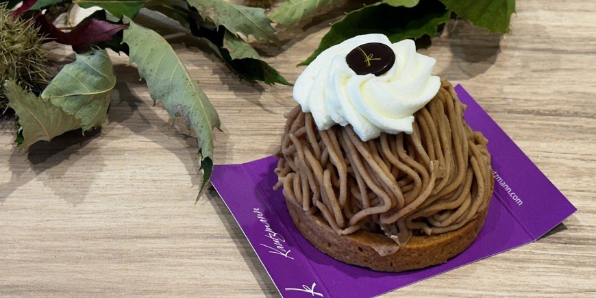 Torche aux marrons de la Pâtisserie Kautzmann sur son carton violet, entière, avec des feuilles et des bogues de châtaignier